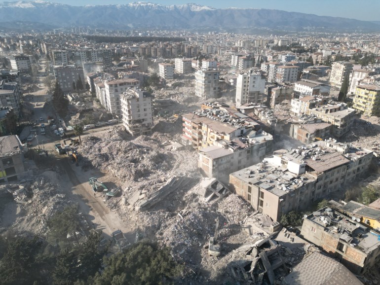 HATAY, TURKIYE - FEBRUARY 16: An aerial view of collapsed buildings as demolishing works and debris removal efforts continue in Antakya district after the powerful twin earthquakes hit Turkiye's Hatay on February 16, 2023. On Feb. 06, a strong 7.7 earthquake, centered in the Pazarcik district, jolted Kahramanmaras and strongly shook several provinces, including Gaziantep, Sanliurfa, Diyarbakir, Adana, Adiyaman, Malatya, Osmaniye, Hatay, and Kilis. Later, at 13.24 p.m. (1024GMT), a 7.6 magnitude quake centered in Kahramanmaras' Elbistan district struck the region. (Photo by Erhan Sevenler/Anadolu Agency via Getty Images)