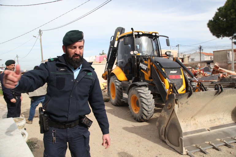 Police officers assist an operation to demolish homes in Segundo Torrao