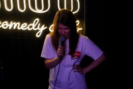 A photo of Margarita performing at a comedy club.