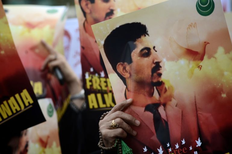 Bahraini Shia demonstrators hold posters of jailed activist Abdulhadi al-Khawaja.