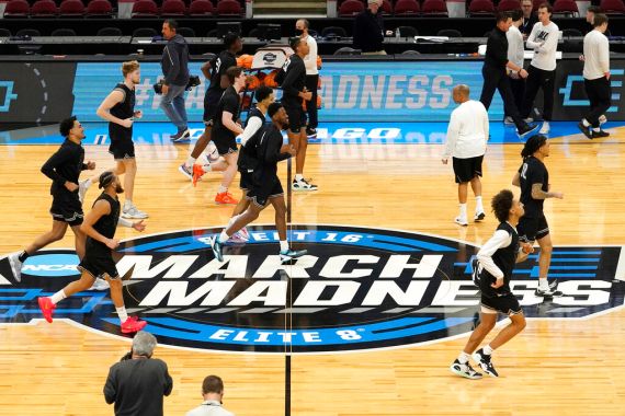 The Providence men's basketball team warm up over the March Madness logo during practice for the NCAA men's college basketball tournament in March 2022.
