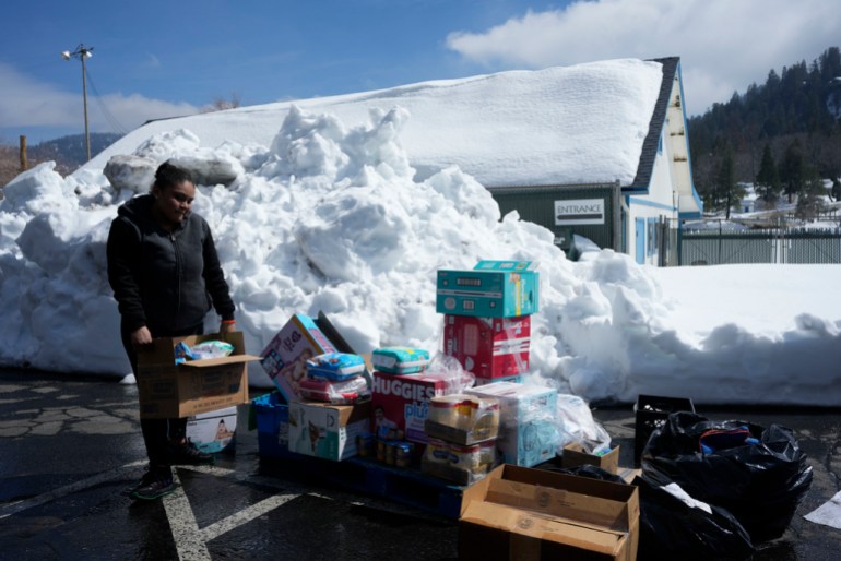 A resident picks up food supplies in preparation for disruptions due to extreme weather