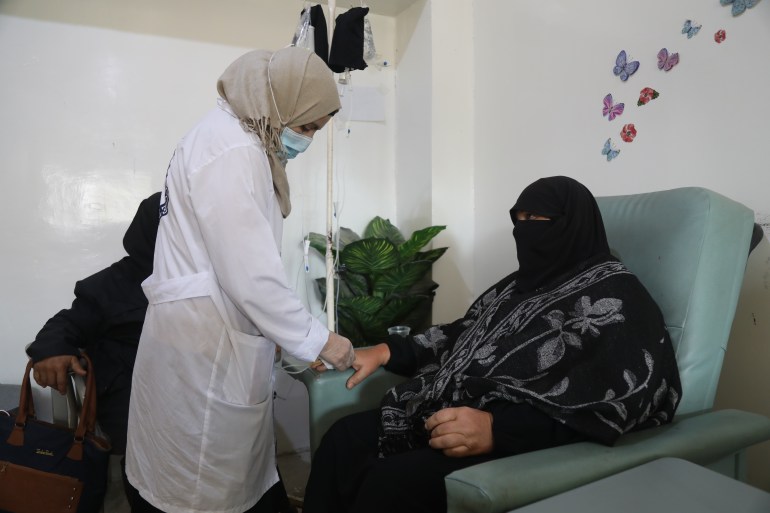 A doctor adjust the needle for Hasna al-Obaid's intravenuous treatment