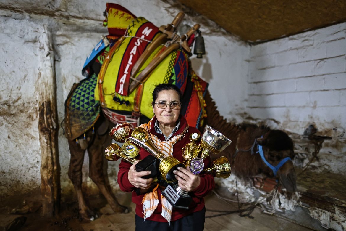 Camel wrestler Habibe Yuksel poses with trophies in the barn in her house in Kutluoba village, Turkey