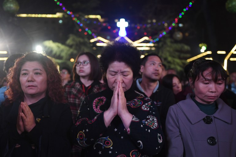 A woman prays with her hands together at an Easter mass at a China government-backed Catholic church in Beijing
