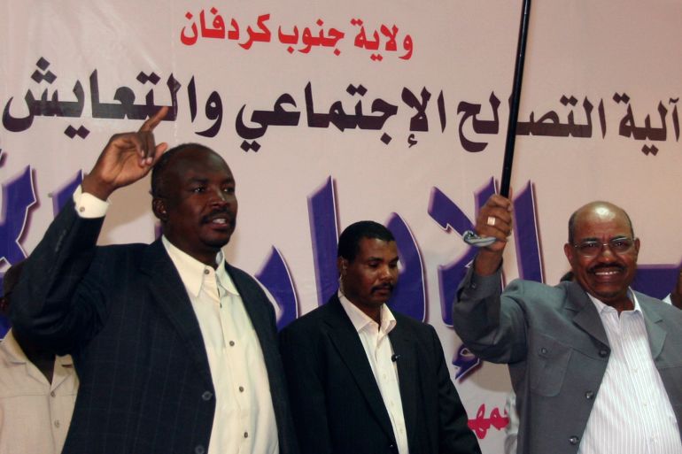 Sudan's President Omar Hassan al-Bashir waves with Governor of South Kordofan Ahmed Haroun, to participants of Civil Administrative Conference during his first visit to Kadogli
