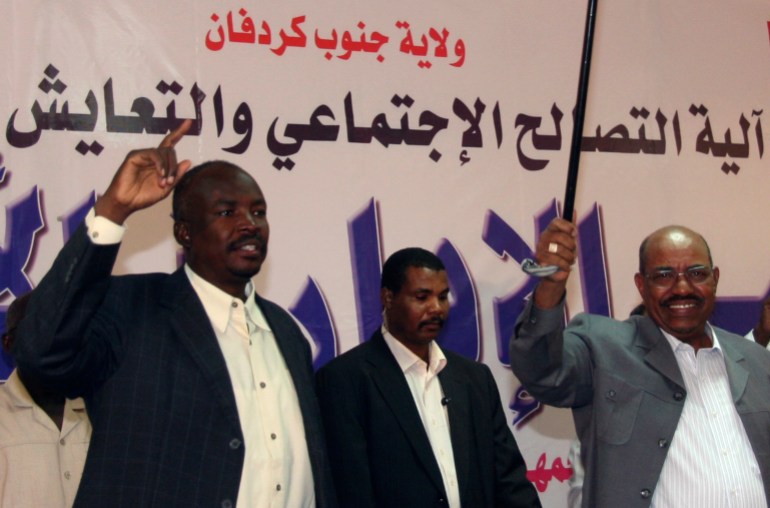 Sudans Präsident Omar Hassan al-Bashir winkt den Teilnehmern der Zivilverwaltungskonferenz während seines ersten Besuchs in Kadogli mit dem Gouverneur von Südkordofan Ahmed Haroun zu