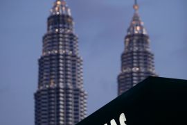 Petronas logo with the company's twin towers in the background.