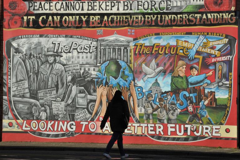 A woman walks past a mural in Lendrick Street, a loyalist area in Belfast, Northern Ireland March 10, 2016