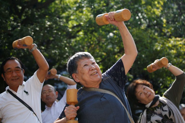 Elderly and middle-aged people exercise with wooden dumbbells during a health promotion event to mark Japan's "Respect for the Aged Day" at a temple in Tokyo's Sugamo district, an area popular among the Japanese elderly, September 17, 2018. REUTERS/Issei Kato
