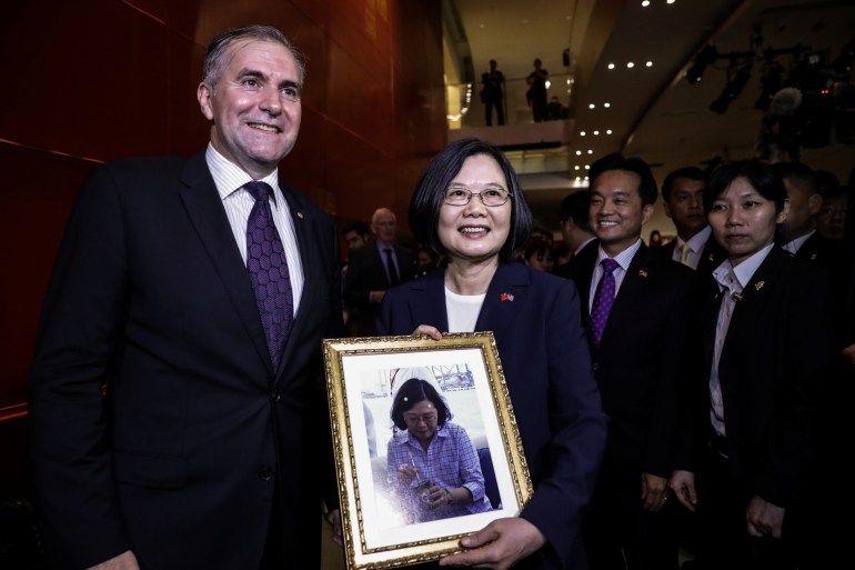 Presiden Tsai Ing-wen memegang foto berbingkai saat berpose dengan duta besar Julio Cesar Arriola Ramirez 