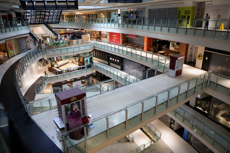 Bagian dalam pusat perbelanjaan dilihat dari lantai atas, memperlihatkan beberapa lantai di bawah tanpa pelanggan