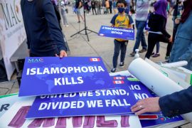 People return signs reading 'Islamophobia kills' at a protest in Toronto, Canada