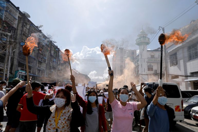 A group of women hold torches high above their heads as they protest against the military coup in Yangon, Myanmar July 14, 2021. REUTERS/Stringer