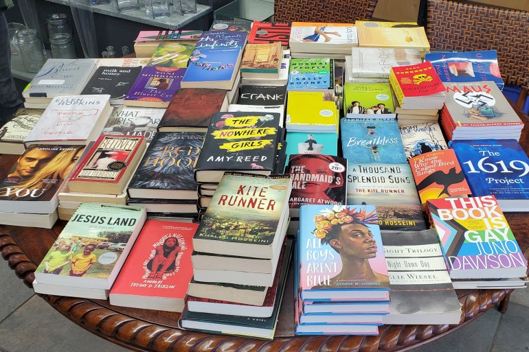 Books banned from libraries sit on a table at a Florida flower shop, June 2022