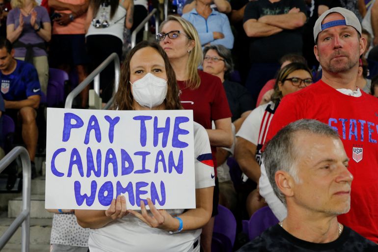 Guests hold signs in support of the Canadian National Women's Soccer Team