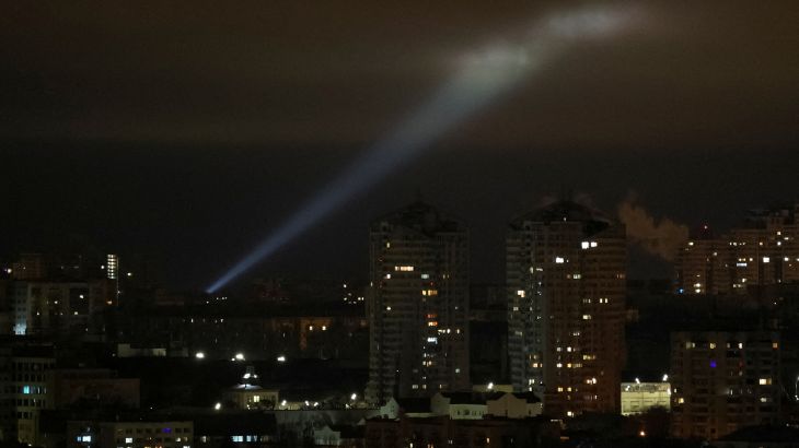 Ukrainian servicemen use a searchlight as they search for drones in the sky over the city during a Russian drone strike, in Kyiv, February 27, 2023