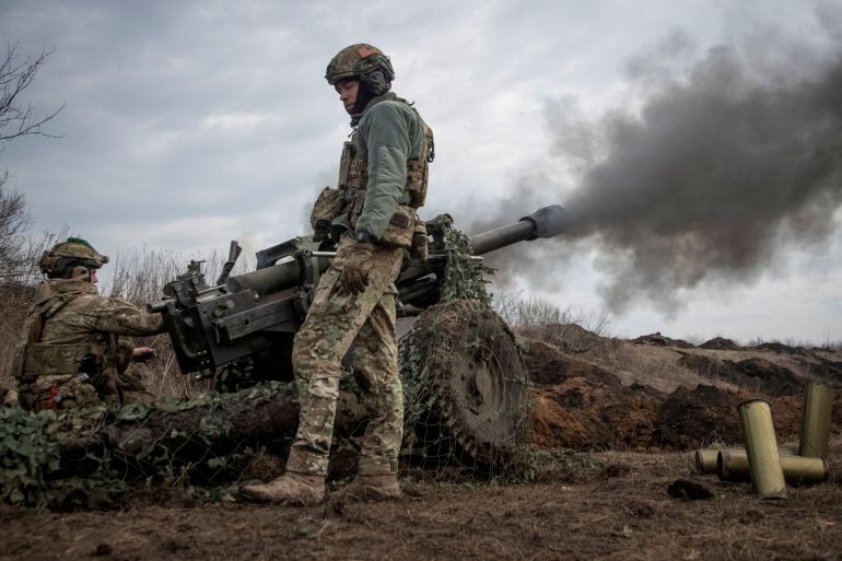 Ukrainian soldiers fire a howitzer near the city of Bakhmut