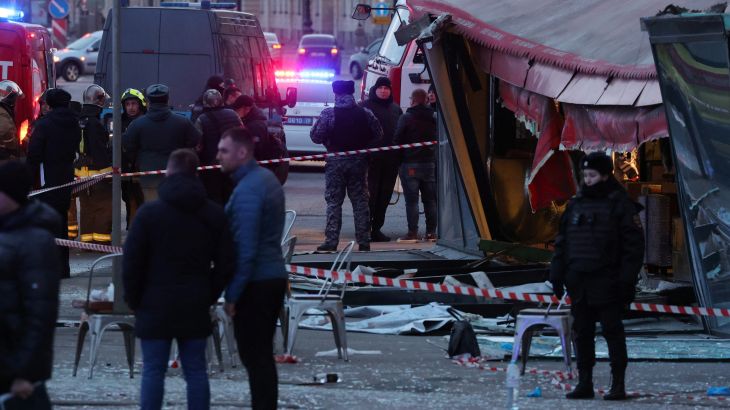 Investigators and members of emergency services work at the site of an explosion in a cafe in Saint Petersburg