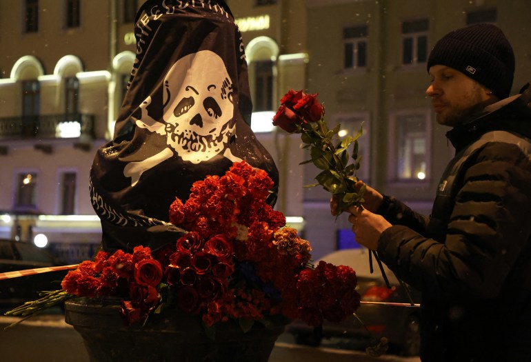 A man places flowers near the site of an explosion in a cafe in Saint Petersburg