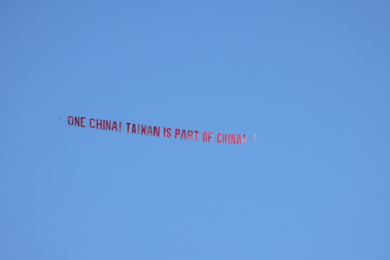 An airplane pulls a banner that reads "One China! Taiwan is part of China."