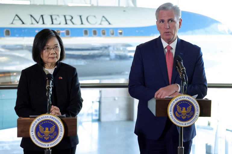 A presidente de Taiwan, Tsai Ing-wen, e o presidente da Câmara dos EUA, Kevin McCarthy, falando em uma coletiva de imprensa.  Eles estão em púlpitos e há um avião atrás deles. 