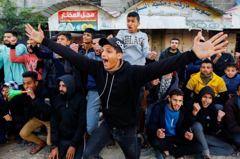 Palestinian men cheer during a football match