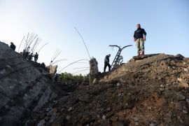 People inspect the damage following Israeli air raids in Ras al-Ain