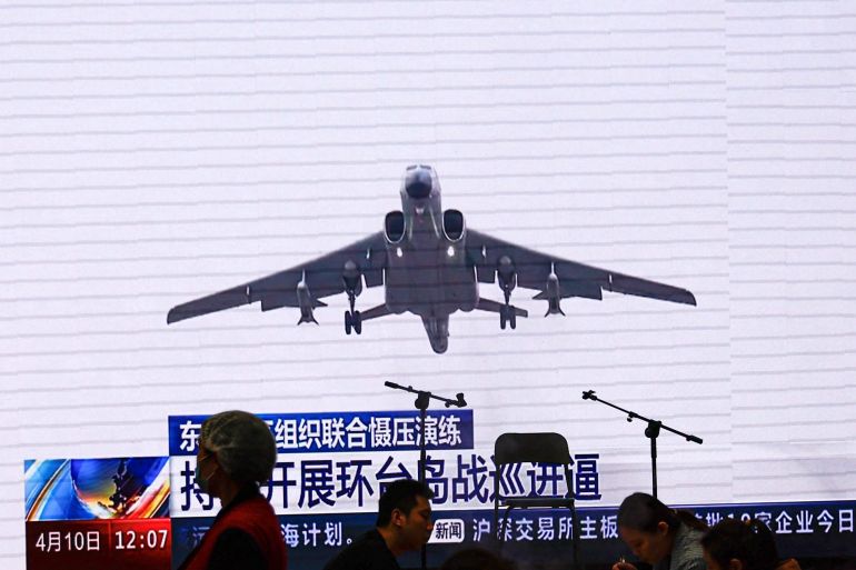 Customers dine near a giant screen broadcasting news footage of aircraft of the Air Force under the Eastern Theatre Command of China's People's Liberation Army (PLA) taking part in a combat readiness patrol and "Joint Sword" exercises around Taiwan, at a restaurant in Beijing, China April 10, 2023.