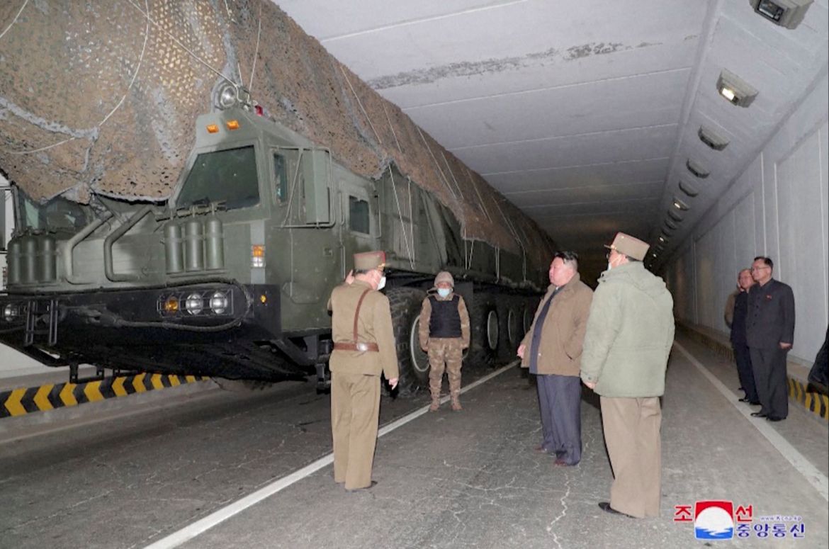 Kim Jong Un in an underground tunnel with military officials and the ICBM launcher