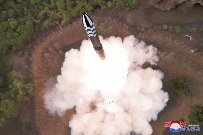 The missile seen from above as it takes off in a cloud of smoke. It has a black and white nose cone.