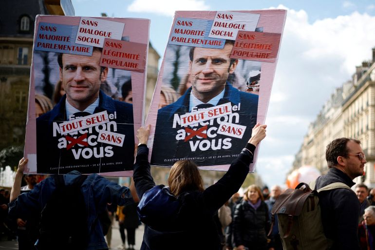Protesters hold placards depicting French President Emmanuel Macron during a demonstration as part of the 12th day of nationwide strikes and protests against French government's pension reform, in Paris, France, April 13
