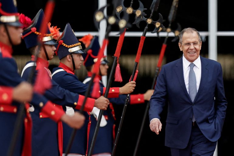 Russia's Foreign Minister Sergey Lavrov walking past an honour guard after a meeting with Brazil's foreign minister, He is smiling and looks very happy.