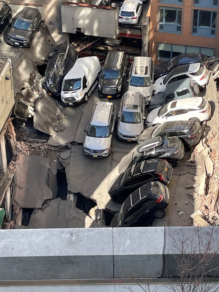 Aerial view of cars parked on crumpled and cracked concrete in collapsed parking lot