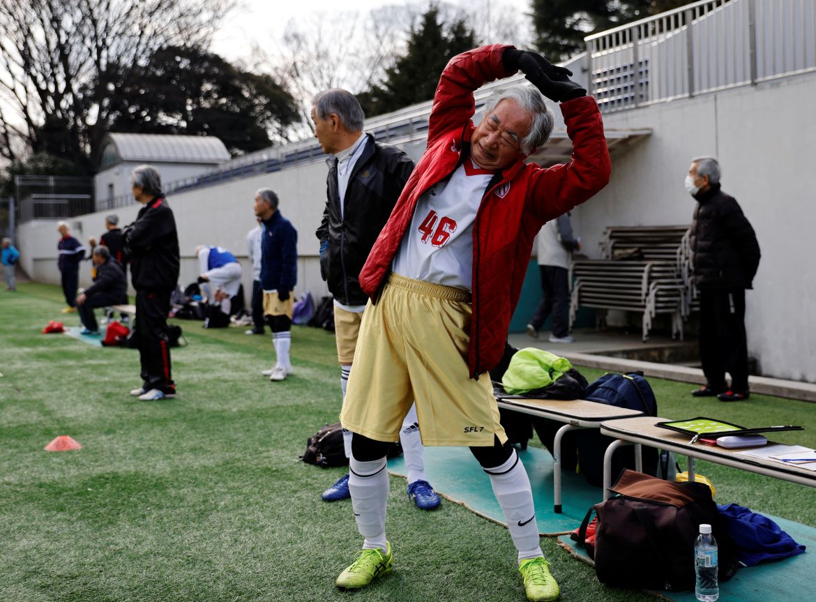 Kozo Ishida, 82, stretches before a pre-season practice match