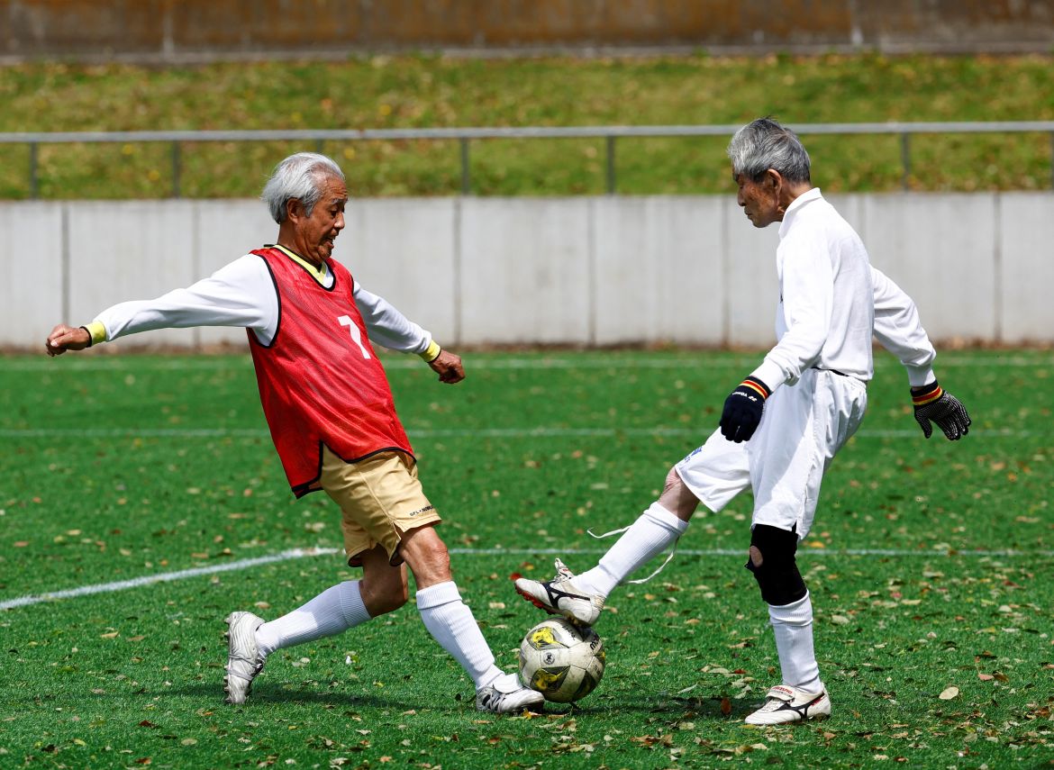 Red Star’s midfielder Mutsuhiko Nomura (left), 83, shoots to score a goal against Blue Hawai’s goalkeeper Hiroshi Nishino, 87, at the SFL (Soccer For Life) 80 League opening match