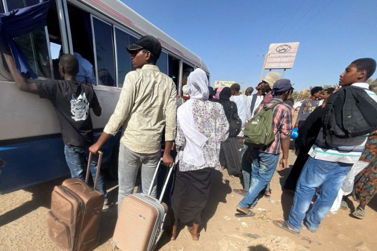 People crowding around a bus in Khartoum as they flee the city.