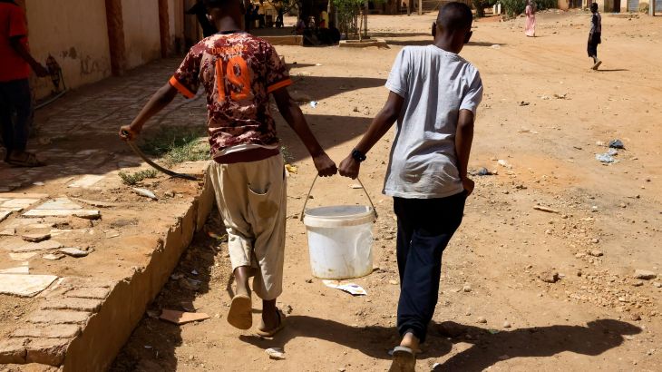 Two young people carrying water.