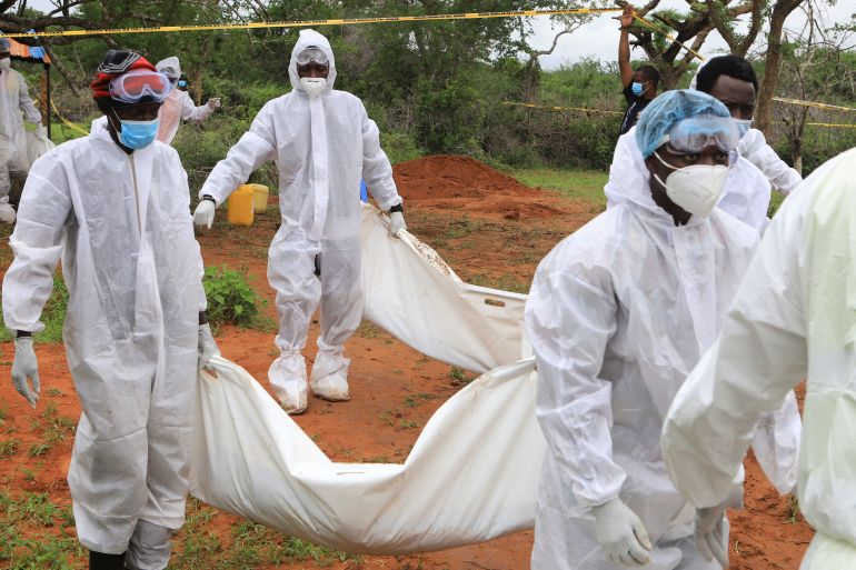 Forensic experts and homicide detectives dressed in white personal protective equipment carry the bodies of suspected members of a Christian cult who believed they would go to heaven if they starved themselves to death, in Shakahola forest of Kilifi county, Kenya.