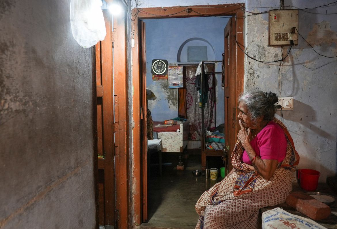 Ram Pyari, a resident of Mumukshu Bhavan, a community home for elderly wishing to live and end their twilight years in the sacred city of Varanasi, sits in her doorway way in Varanasi