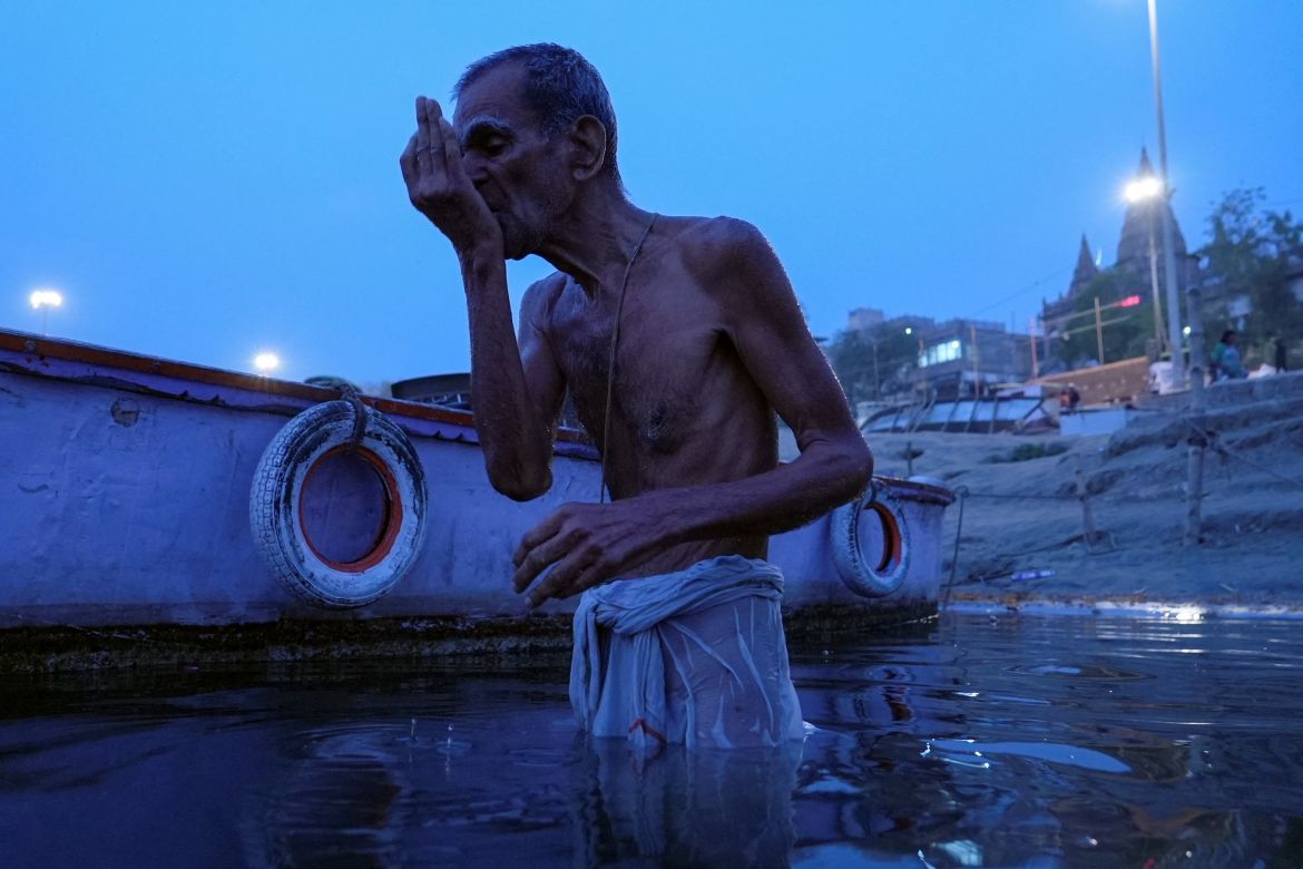 An 82-year-old man drinks water from the Ganges River during a morning prayer in Varanasi.
