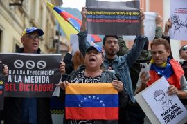 Protesters gather with Venezuelan flags and signs