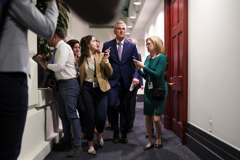 House Speaker Kevin McCarthy walks through the halls of Congress, surrounded by aides and reporters