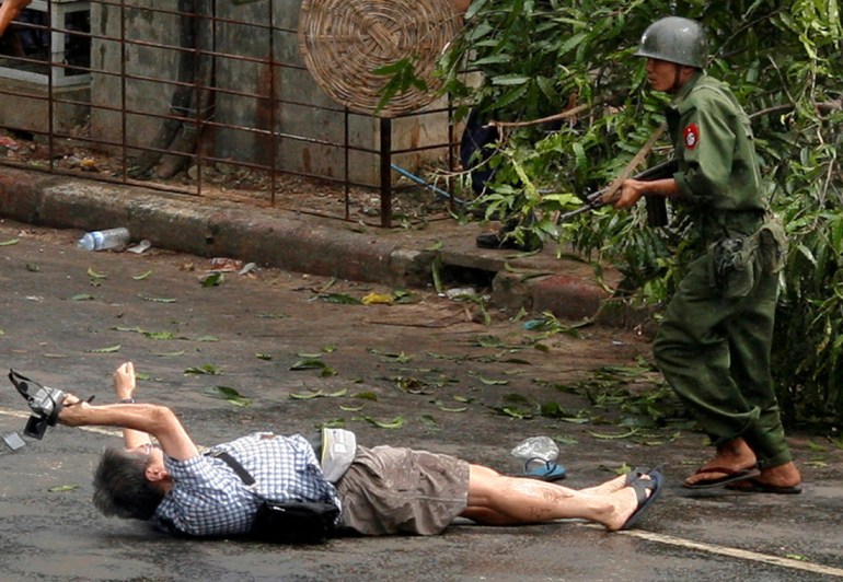 Кенджи Нагаи из вооруженных сил Филиппин пытается сфотографировать, как он ложится после того, как полиция и армейские офицеры стреляют, а затем атакуют протестующих в центре Янгона 27 сентября 2007 года. REUTERS/Adris Latif