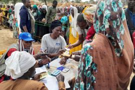 Sudanese refugees who have fled the violence in their country queue to receive food supplements from World Food Programme (WFP) near the border between Sudan and Chad in Adre,