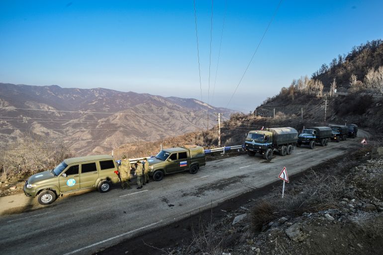 Russian peacekeepers are seen deployed at the Lachin corridor, the Armenian-populated breakaway Nagorno-Karabakh region's only land link with Armenia, as Azerbaijani environmental activists protest what they claim is illegal mining, on December 26, 2022. Azerbaijani activists who have blocked the sole road connecting Karabakh with Armenia rejected on December 26 Yerevan's accusations of provoking a humanitarian crisis in the enclave. But locals in Karabakh interviewed by AFP decried the dire consequences of the blockade, which they say is aimed at chasing ethnic Armenians from the region. (Photo by TOFIK BABAYEV / AFP)