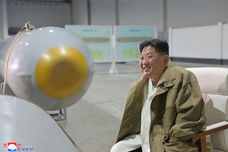 Kim Jong Un smiling as he sits next to the Haeil underwater attack drone.