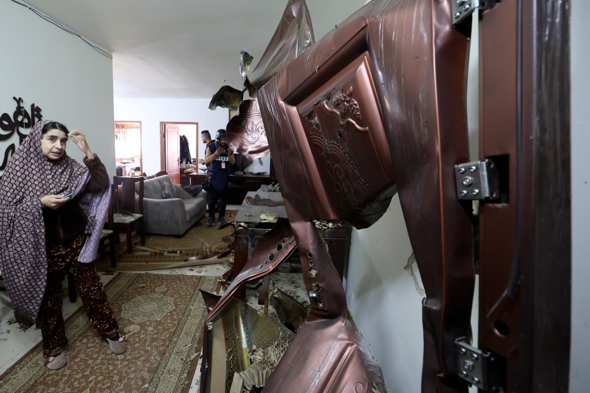 Palestinians inspect the damage to a house following an Israeli raid in the city of Nablus