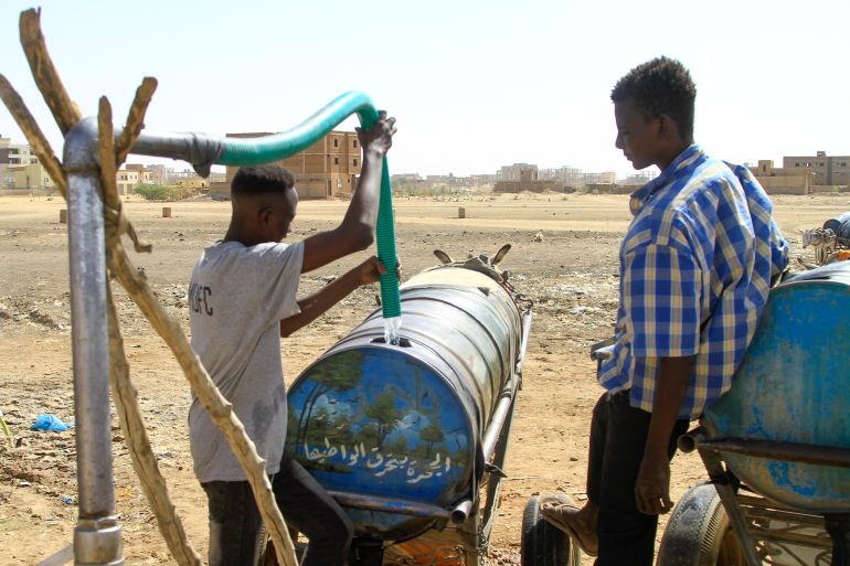 People fill barrels with water in southern Khartoum on April 22, 2023, amid water shortages