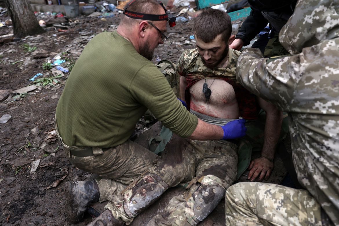 Military paramedics treat an Ukrainian injured serviceman on a street in the frontline city of Bakhmut